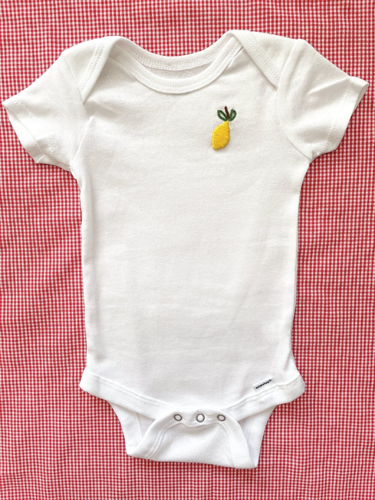 Lemon hand embroidery on white baby onesie