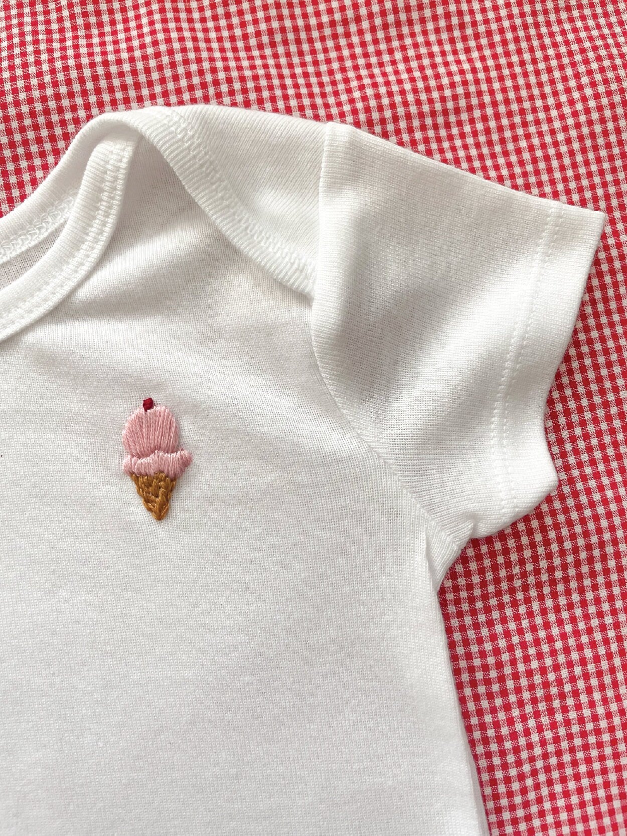 ice cream hand embroidery on white baby onesie