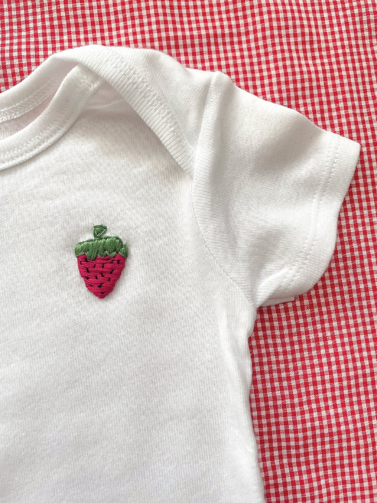 strawberry hand embroidery on white baby onesie