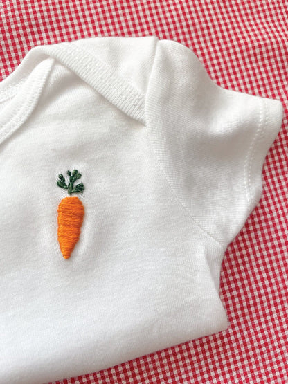 carrot hand embroidery on white baby onesie